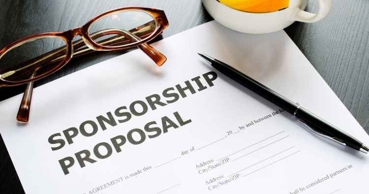 Sponsorship proposal document on a desk with a black pen, eyeglasses and a cup of tea.