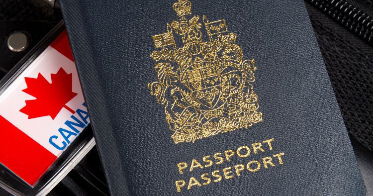 Close-up of a Canadian passport with a gold coat of arms beside a luggage tag featuring the Canadian flag.